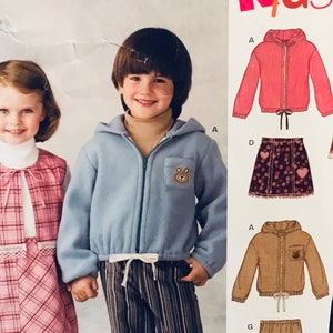 Puede incluir: Un patrón de costura para ropa de niños. El patrón incluye una chaqueta de vellón azul con una aplicación de oso, una chaqueta de vellón rosa, un chaleco a cuadros, una falda a cuadros, una chaqueta de pana marrón y un pantalón a rayas.
