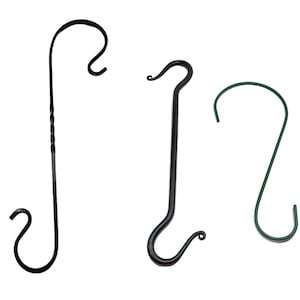 Puede incluir: Tres ganchos de metal, uno negro con un diseño retorcido, uno negro con una curva simple y uno verde con una curva simple.