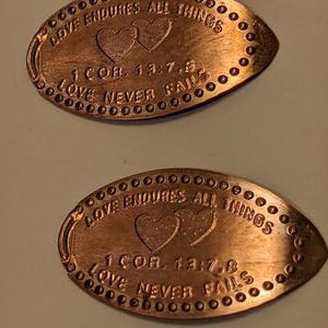 2 penny allongés en cuivre « LOVE NEVER FAILS »