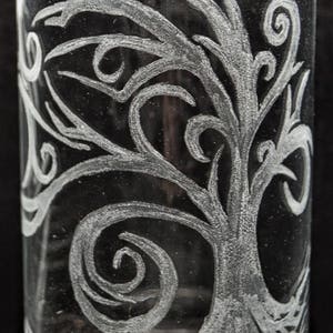 May include: A clear glass tumbler with a white etched design of a tree with swirling branches and roots.