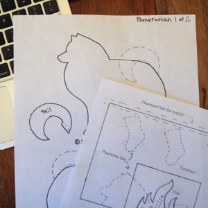 Op de afbeelding: Een zwart-witte lijntekening van een dwergspits met de tekst "Pomeranian 1 of 2" en "tail" op de afbeelding. De afbeelding bevat ook een diagram met plaatsingslijnen voor een schouw en een haard.