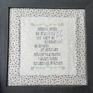 May include: A framed embroidery with a beige background and a poem about spring. The poem reads: "spring is sprung, the grass is riz see where all the flowers is? All the birds are on the wing NOW isn't that obserd! I always thought the wing was on the bird"