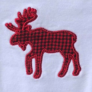 May include: Red and black plaid moose applique on a white background.