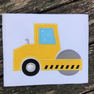 Puede incluir: Vehículo de construcción de juguete amarillo y gris con una llanta negra y un parachoques rayado negro y amarillo.