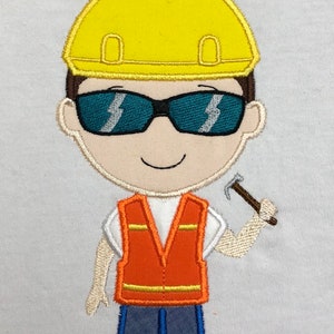 Pode incluir: Bordado de um trabalhador da construção civil de desenho animado usando um capacete amarelo, óculos de sol e um colete de segurança laranja. O trabalhador está segurando um martelo e usando calças azuis.
