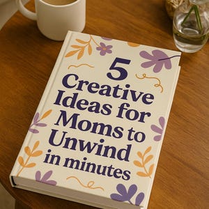 Könnte beinhalten: Ein Buch mit dem Titel "5 Creative Ideas for Moms to Unwind in minutes" mit floralen Illustrationen liegt auf einem Holztisch. Eine weiße Tasse mit Kaffee und eine kleine Vase mit Grünzeug stehen ebenfalls auf dem Tisch.