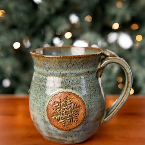 Taza de café de cerámica con copos de nieve de invierno y reposapiés de arcilla navideña