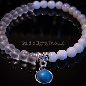 Weißes und gefrostetes klares Perlenarmband mit blauem Anhänger