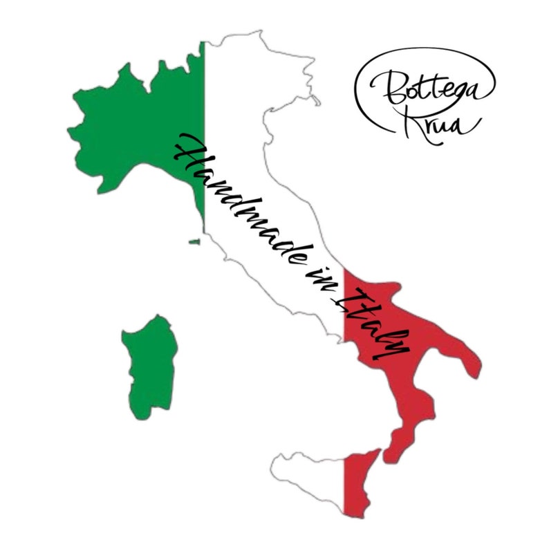 May include: An outline of Italy with the Italian flag colors, green, white, and red, superimposed on the map. The text "Handmade in Italy!" is written on the map. The text "Bottega Rua" is written in a circle above the map.