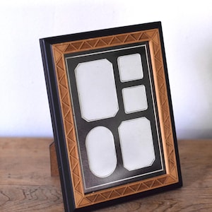 May include: A rectangular multi-opening picture frame with a black outer border and an inner border featuring a light brown wood-toned geometric triangle pattern. The frame contains four distinct white mat openings for photographs.