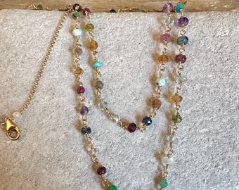 Puede incluir: Un delicado collar de cadena dorada con una serie de pequeñas cuentas de piedras preciosas facetadas y multicolores espaciadas uniformemente. El collar incluye un cierre de mosquetón dorado y una cadena extensora ajustable con una cuenta.