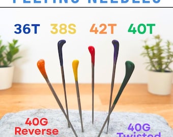 Puede incluir: Siete agujas de fieltro de diferentes tamaños y colores están dispuestas en círculo sobre una superficie de fieltro gris. Las agujas están etiquetadas con sus tamaños: 36T, 38S, 42T, 40T, 40G Reverse y 40G Twisted.