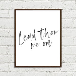 Op de afbeelding: Een zwart-wit aquarelprint met de tekst "Lead thou me on" in een cursief schrift.