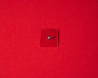 Título : "Red 1" es un pequeño tapiz tejido que incorpora alambre de púas dentro de un campo de tela roja.