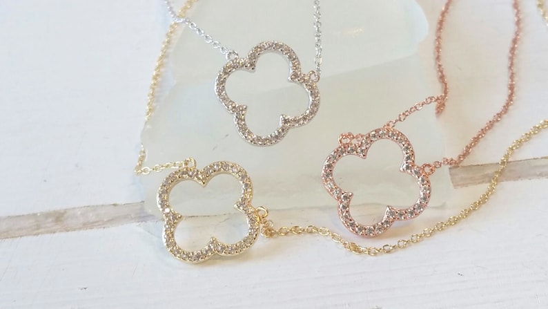 Puede incluir: Tres delicados collares con un dise&ntilde;o de colgante de tr&eacute;bol de cuatro hojas. Cada colgante est&aacute; incrustado con piedras transparentes brillantes y est&aacute; disponible en oro, plata y oro rosa.