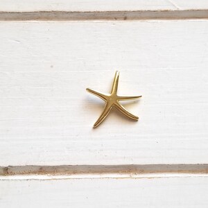 May include: A gold-colored starfish charm pendant.
