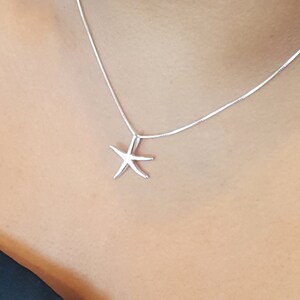 May include: A silver chain necklace with a simple starfish pendant.