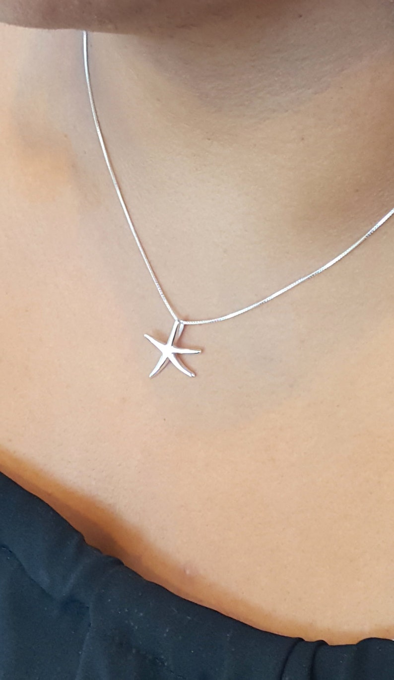 May include: A silver chain necklace with a simple starfish pendant.