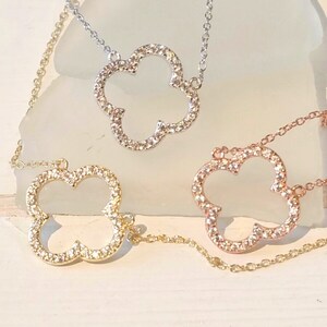 Puede incluir: Tres delicados collares con un colgante en forma de tr&eacute;bol. Cada colgante est&aacute; incrustado con peque&ntilde;as piedras brillantes. Los collares son de oro, plata y oro rosa.