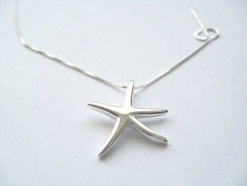 May include: A silver chain necklace with a silver starfish pendant.