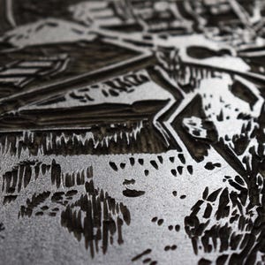The image shows a part of the printmaking process. Linocut is a printing technique that requires carving in linoleum block. After carving you put a layer of the color and print it. This image shows the inked matrix.