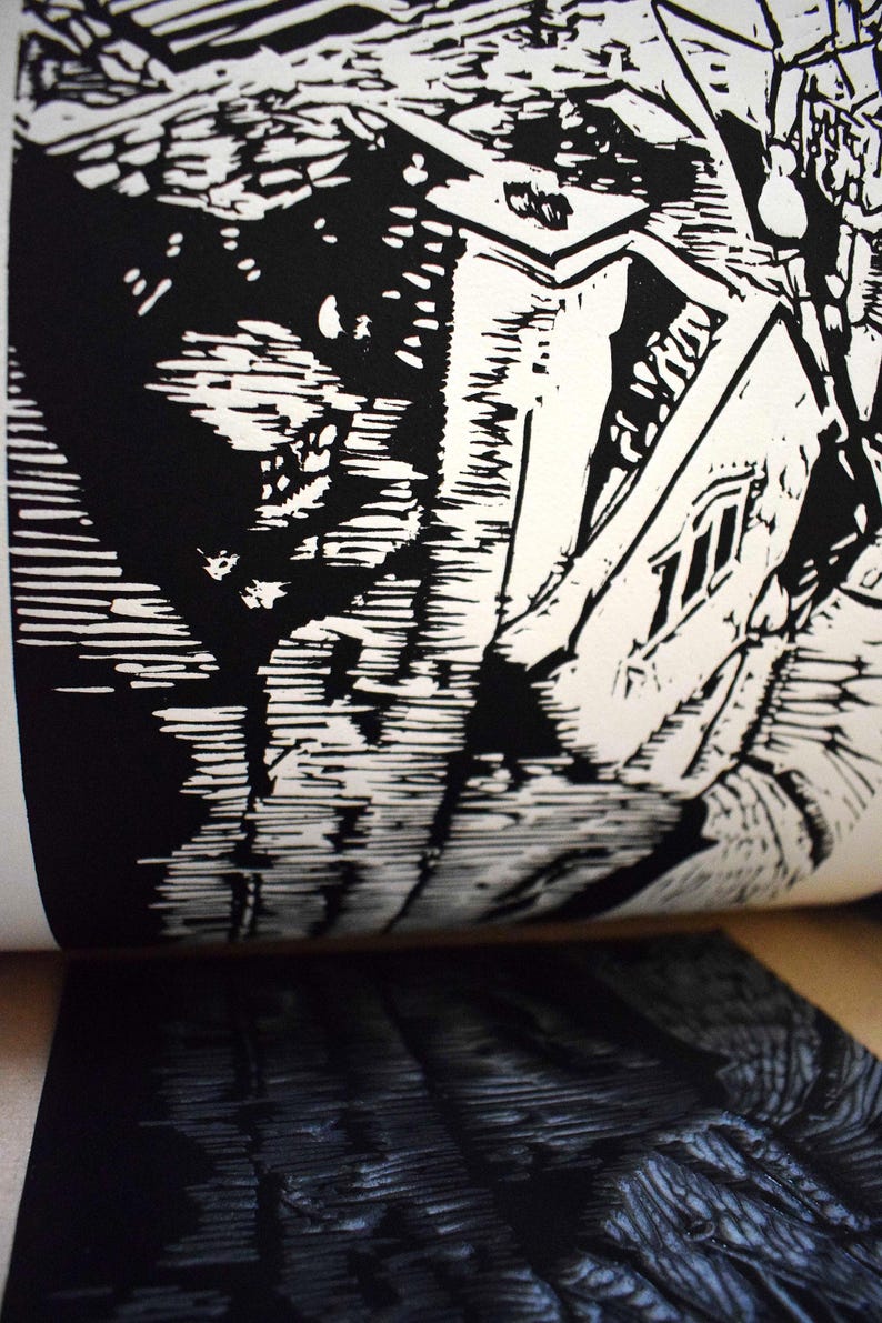 The image shows a part of the printmaking process. Linocut is a printing technique that requires carving in linoleum block. After carving you put a layer of the color and print it. This is the moment when you peel the print of the matrix.
