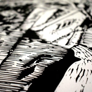 The image shows a detail of the print shot at a diagonal angle. In the bottom left corner is the lower part of the building that is in shadow. In the lower right corner is a pavement. These parts are in focus while the rest is blurry.