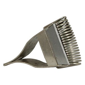 Peut inclure: Un outil en métal argenté avec un peigne à ressort et une poignée. Le peigne est conçu pour enlever les peluches des vêtements.