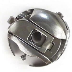 May include: A silver sewing machine bobbin case with a spring and a small metal latch.