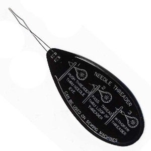 May include: Black needle threader with white printed instructions. The tool features a wire loop for threading needles. Text on the tool reads "NEEDLE THREADER" and "CAN BE USED ON SEWING MACHINES."