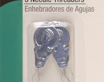 Könnte beinhalten: Packung mit drei silbernen Nadeleinfädler. Auf der Verpackung steht "3 Needle Threaders" und "For most hand & machine needles". Die Einfädler befinden sich in einer transparenten Kunststoffverpackung.