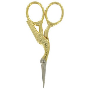May include: Gold-toned, decorative scissors with a bird-shaped handle. The scissors have a pointed tip and a detailed design.