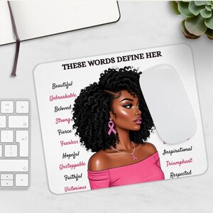 May include: A white rectangular mousepad featuring an illustration of a woman with dark curly hair and pink accessories. The mousepad has the text "THESE WORDS DEFINE HER" and words like "Beautiful", "Unbreakable", and "Victorious". A white computer mouse is on the right.