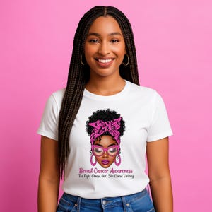 May include: White t-shirt featuring a graphic of a woman with a pink headscarf, glasses, and earrings. The graphic includes the text "Breast Cancer Awareness The Fight Chose Her, She Chose Victory."
