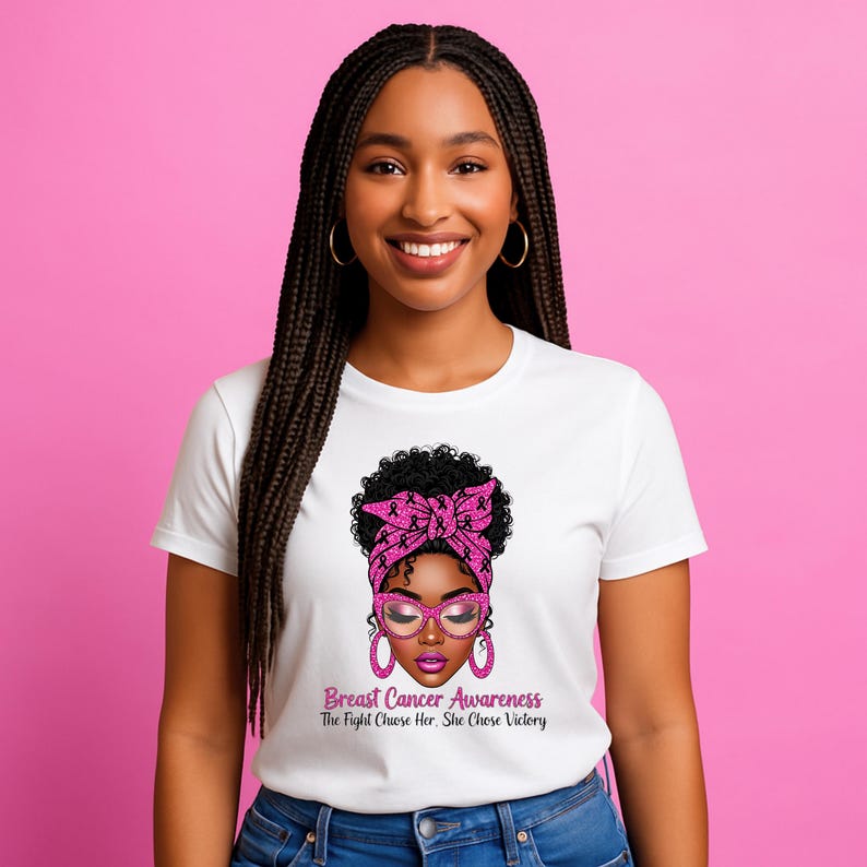 May include: White t-shirt featuring a graphic of a woman with a pink headscarf, glasses, and earrings. The graphic includes the text "Breast Cancer Awareness The Fight Chose Her, She Chose Victory."