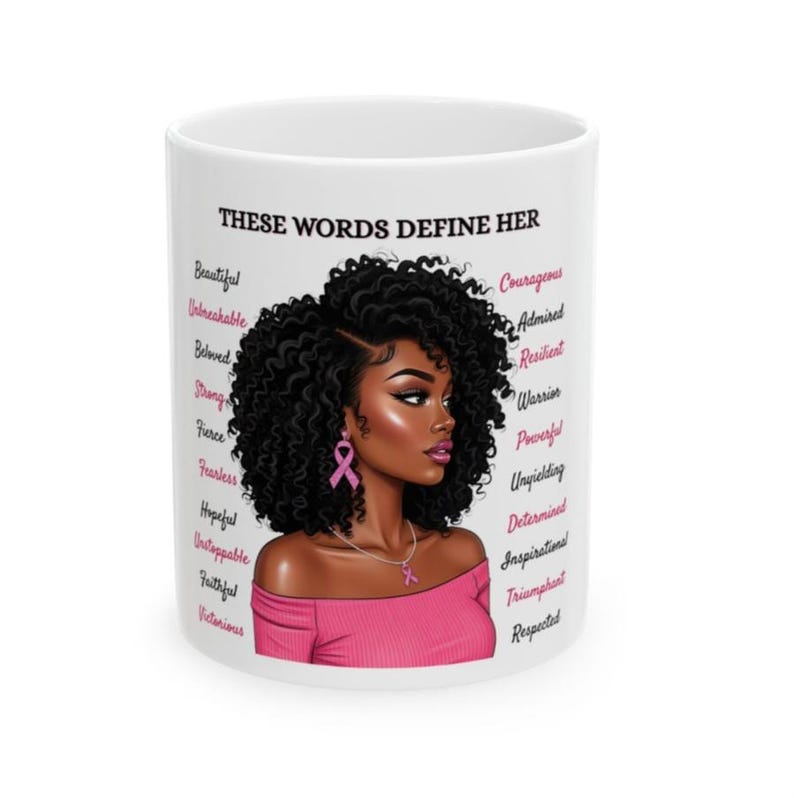 May include: White ceramic mug featuring a portrait of a woman with curly black hair, wearing a pink top and earrings. The mug has the text "THESE WORDS DEFINE HER" and a list of empowering words in pink.