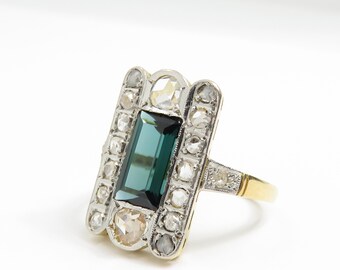 May include: A vintage ring with a rectangular green gemstone surrounded by smaller diamonds. The ring is set in silver and gold.
