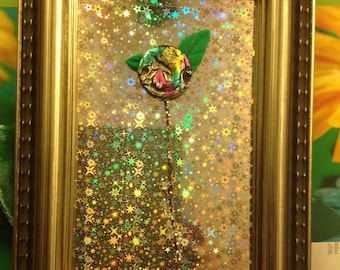 ART ,MIXED MEDIA Miniature floral sculpture,painted button and green leaves hand made clay,framed with holograph paper