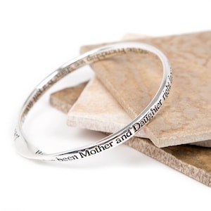 May include: Silver bangle bracelet with the inscription "I have been Mother and Daughter right from the start".