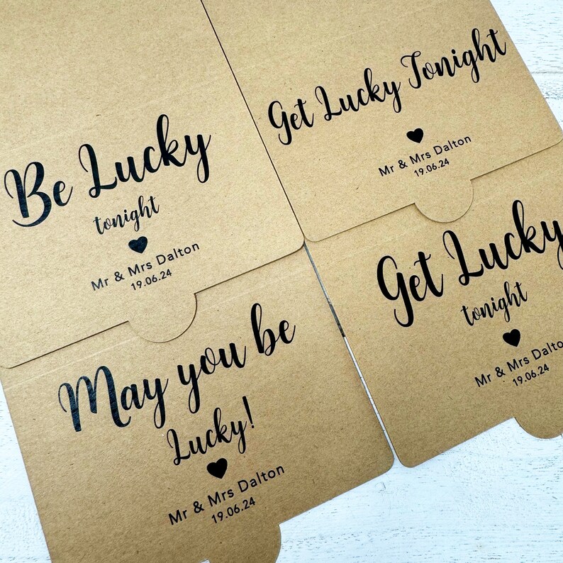 May include: Three brown paper favor boxes with the text "Be Lucky tonight", "Get Lucky Tonight", and "May you be Lucky!"  Each box has the text "Mr & Mrs Dalton 19.06.24" printed on the bottom.