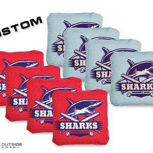 May include: Set of eight bean bags with a custom design featuring a shark with crossed baseball bats and the text "Sharks Baseball Club". The bean bags are half red and half blue.