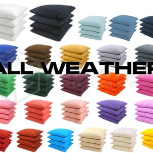 May include: Stacks of square bean bags in various colors, including white, black, blue, brown, and yellow. The text "ALL WEATHER" is displayed in large, bold, black letters across the center of the image. Other colors include green, orange, and pink.