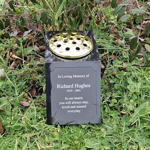 May include: Black granite memorial with a gold flower vase and inscription "In Loving Memory of Richard Hughes 1935-2001 In our hearts you will always stay, loved and missed everyday"