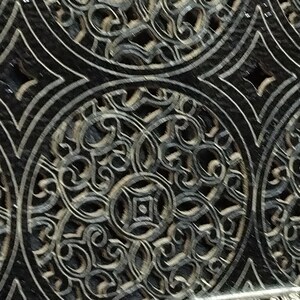 Puede incluir: Primer plano de una superficie decorativa con un patr&oacute;n repetitivo. El dise&ntilde;o presenta c&iacute;rculos superpuestos con detalles intrincados y arremolinados en tonos grises y negros. El patr&oacute;n tiene una est&eacute;tica vintage y ornamentada.