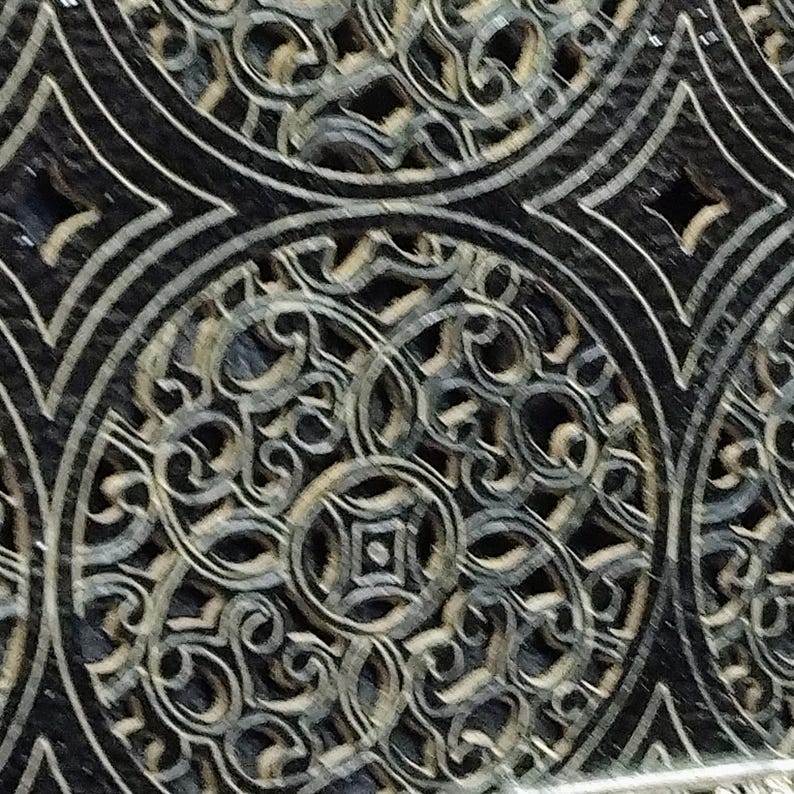 Puede incluir: Primer plano de una baldosa decorativa con un patr&oacute;n repetitivo. El dise&ntilde;o presenta formas circulares y de diamante con intrincados adornos en tonos grises y negros. La baldosa tiene un acabado brillante.