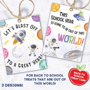 May include: Two white rectangular gift tags with space-themed illustrations. One tag says "Let's Blast Off To A Great Year!" with a rocket, astronaut, and planets. The other says "This School Year Is Going To Be Out Of This World!" with a UFO and planets.