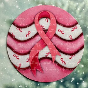May include: A pink and white circle with a pink ribbon design. The ribbon is layered and has a 3D effect. The background is a blurred image of a green and white snowy scene.