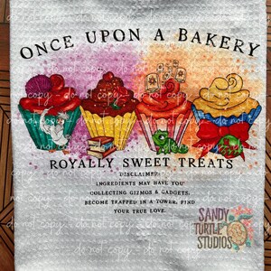 May include: A white background with a watercolor design of three cupcakes with a pink, red, orange, and yellow color scheme. The text "Once Upon A Bakery" is at the top of the image. The text "Royally Sweet Treats" is below the cupcakes. The text "Disclaimer: Ingredients may have you collecting gizmos & gadgets. Become trapped in a tower, find your true love." is below the text "Royally Sweet Treats". The text "Sandy Turtle Studios" is at the bottom of the image.