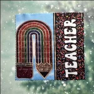 May include: A blue and black fabric patch with a rainbow and pencil design on the left side and the word "TEACHER" in white letters on the right side. The background is black with colorful confetti.