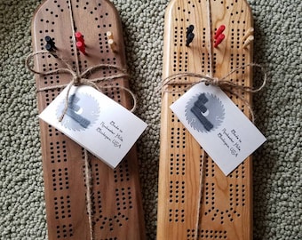May include: Two wooden cribbage boards with a natural wood finish. Each board is wrapped in twine and has a small tag that reads "Made in Rochester Hills, Michigan, USA".